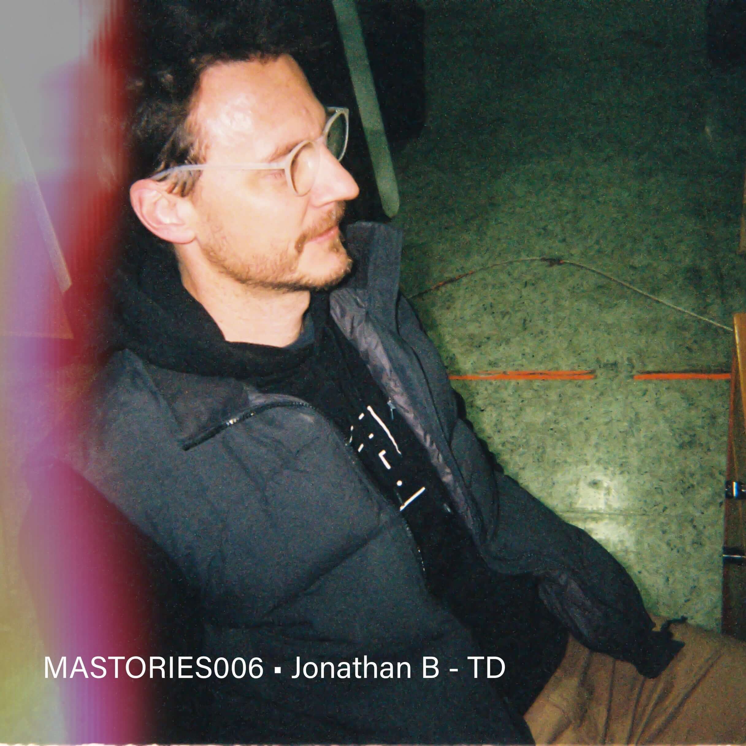 Profile of a man seated, wearing glasses, featured in MASTORIES06 article.