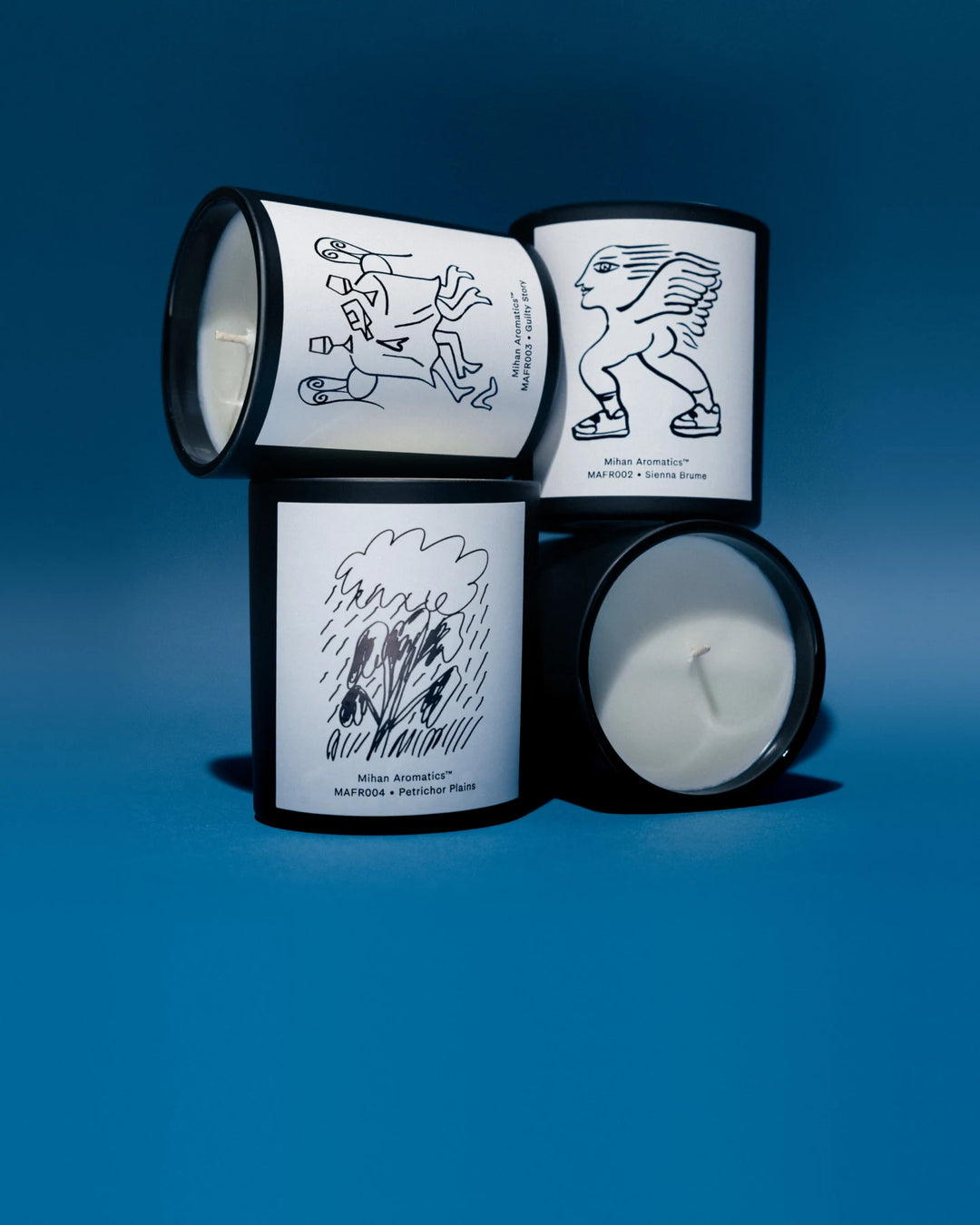 Mihan Aromatics candles stacked on a blue backdrop
