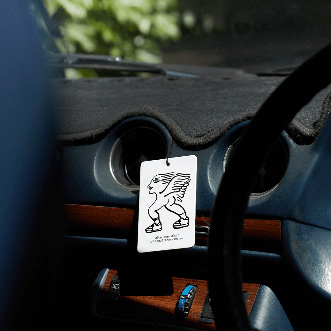 Sienna Brume Air Fragrance Card from Mihan Aromatics hanging in a car dashboard for a captivating scent.