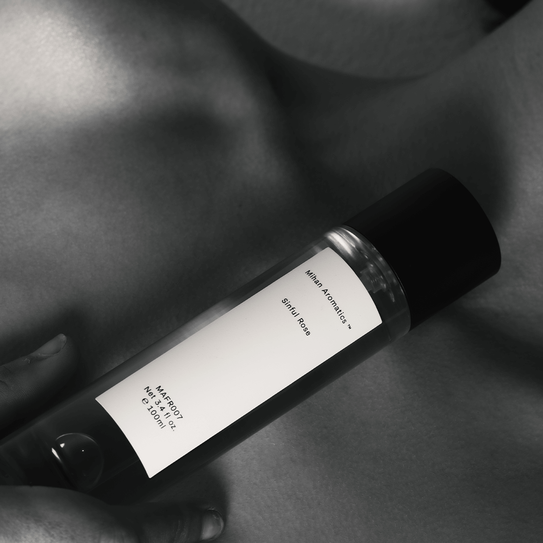 Bottle of Sinful Rose Parfum by Mihan Aromatics held close, showcasing an elegant design and intimate essence.