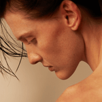 Profile close-up of a woman with flowing hair, emphasizing her natural features and serene expression.