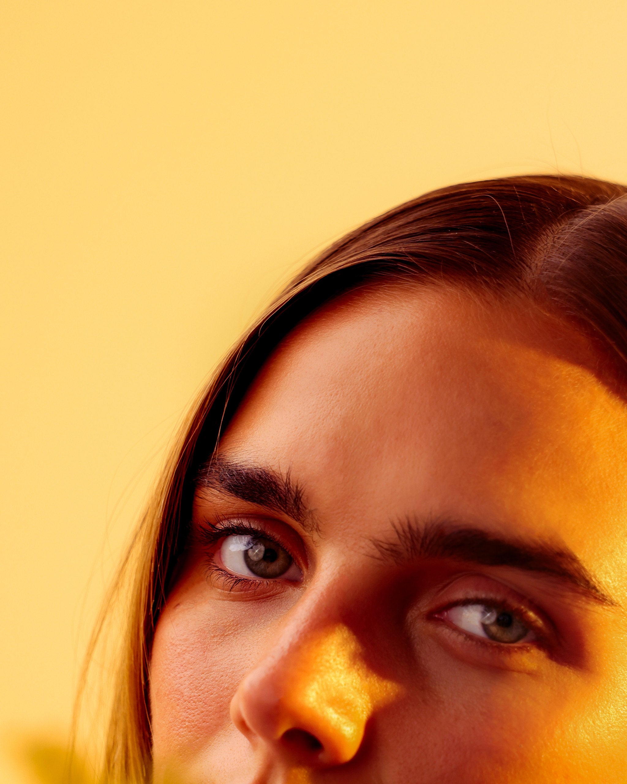 Close portrait in golden light behind soft wattle blossom, Mihan Aromatics Series Three campaign
