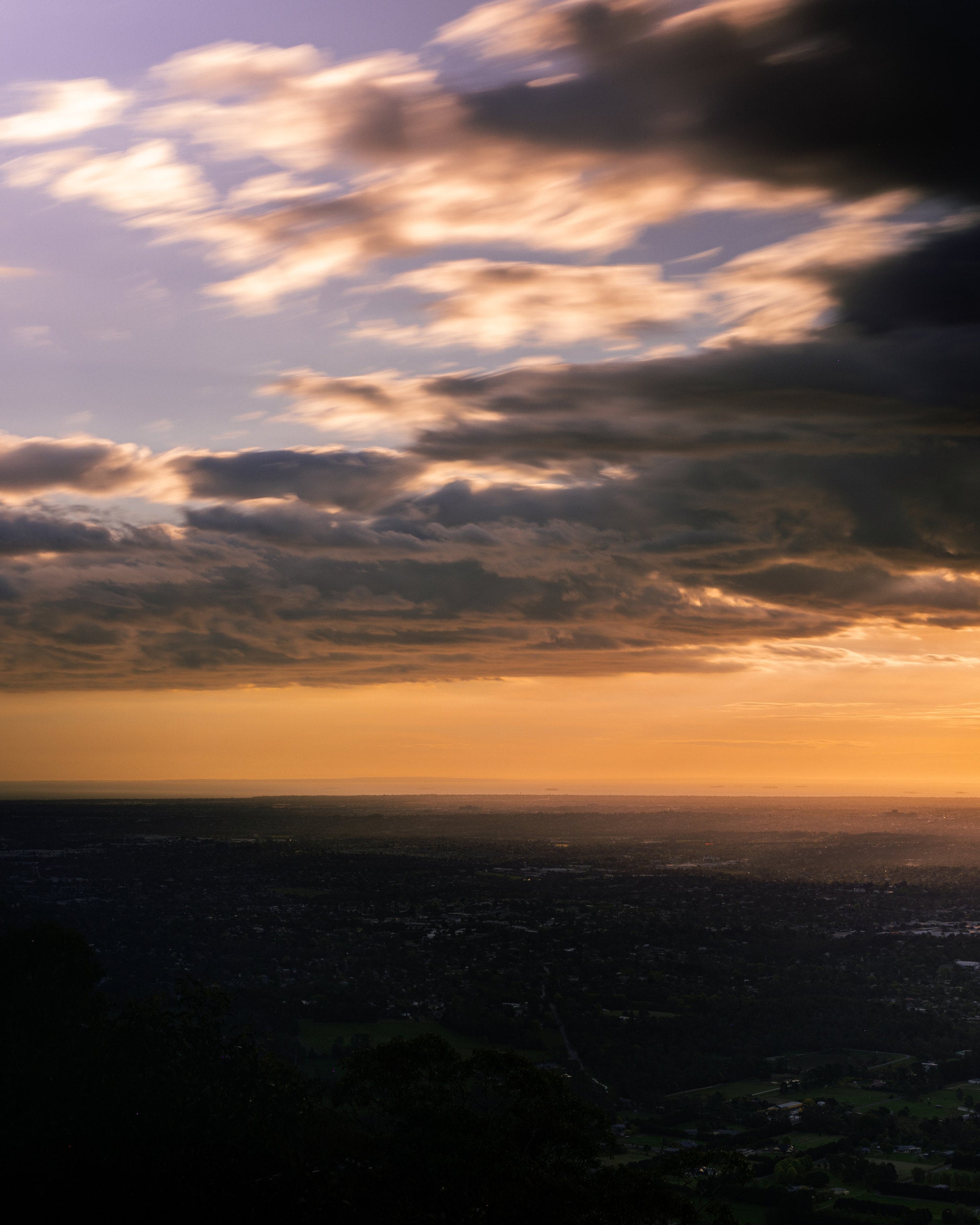 Sunset breaking beneath the clouds over a valley in the Victorian bush, Mihan Aromatics Series Three campaign