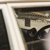 Mihan Aromatics Guilty Story Air Fragrance hanging from the rear view mirror of a vintage car