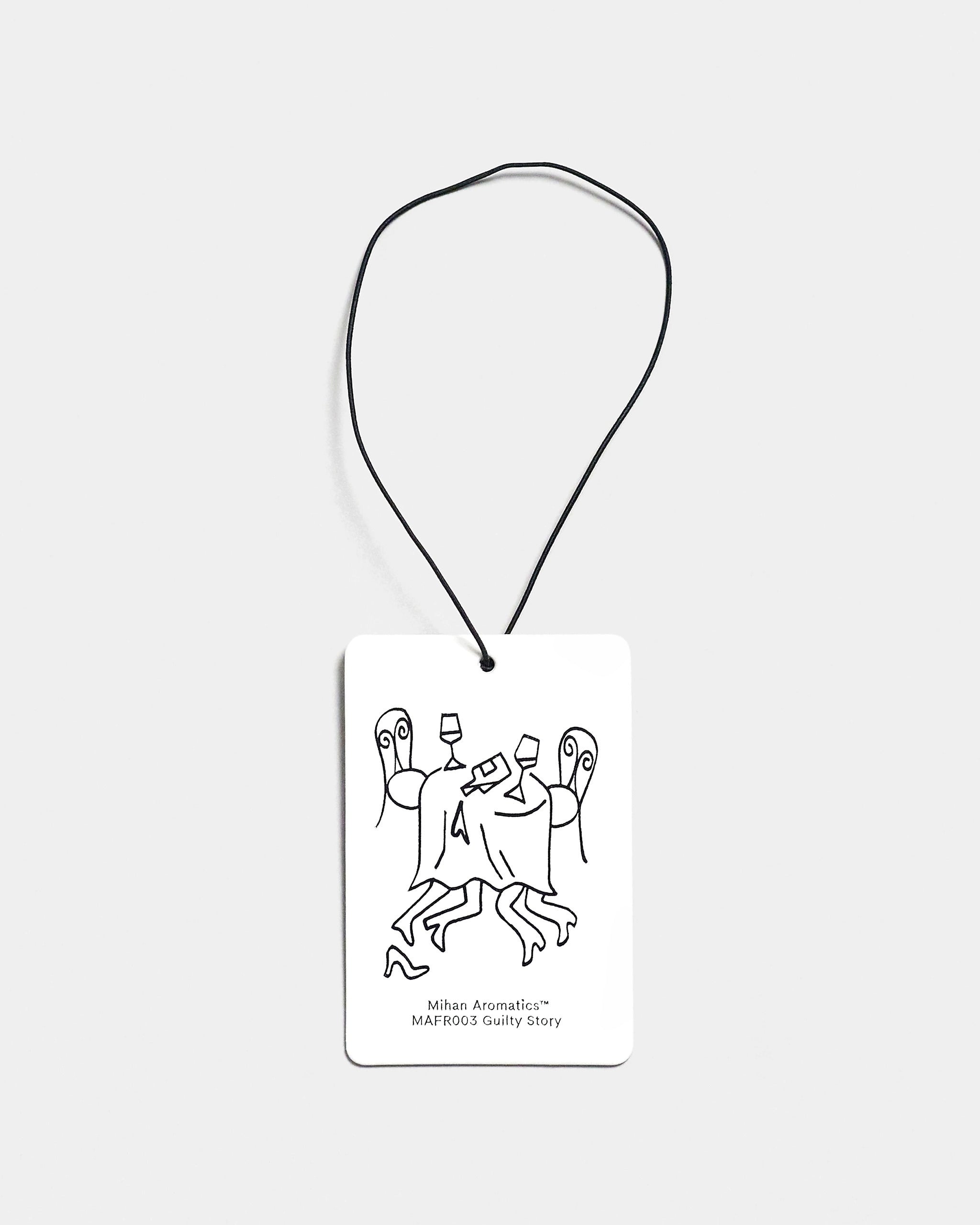 Mihan Aromatics Guilty Story Air Fragrance card with illustrated design and black cord on a Studio Grey backdrop