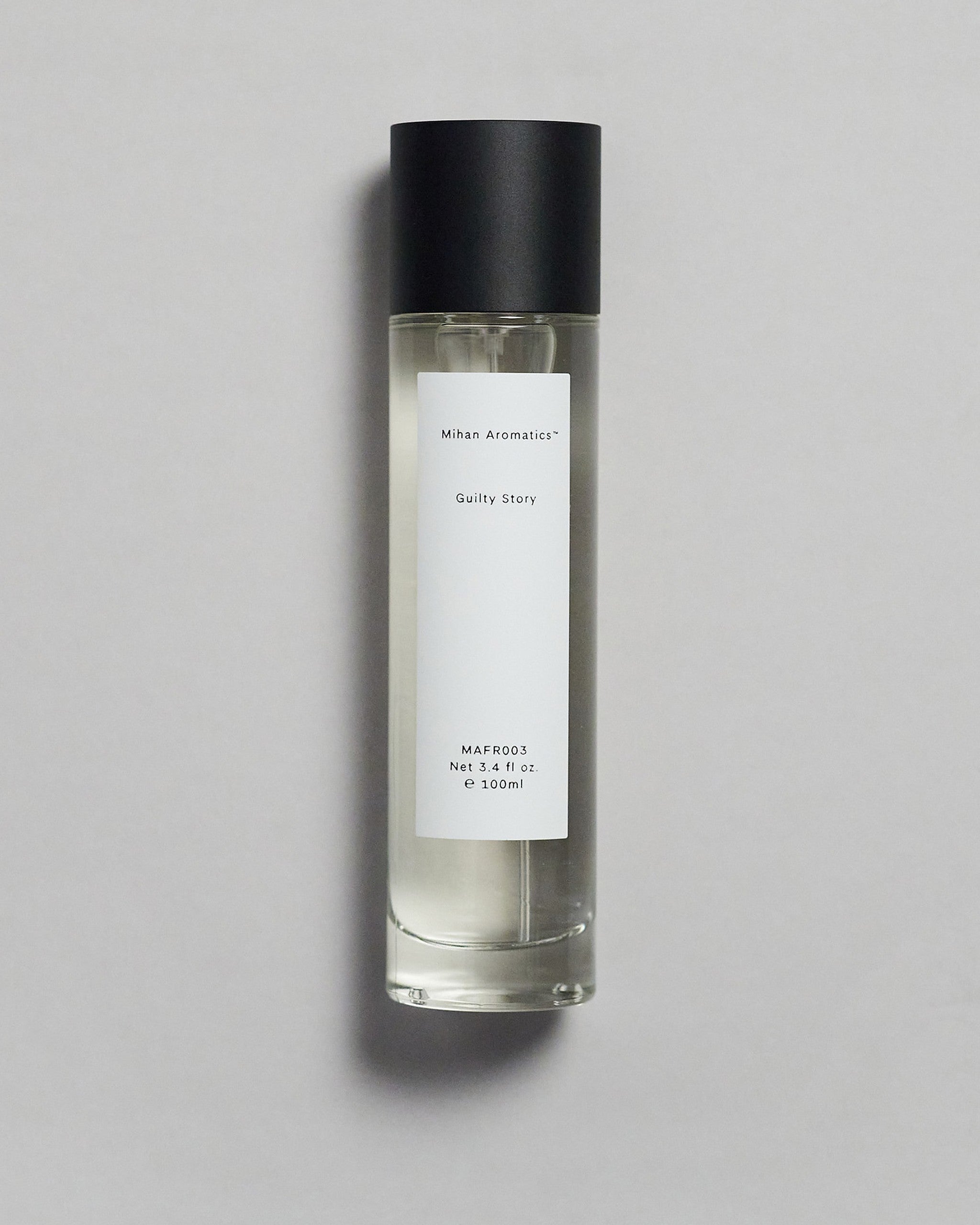 Mihan Aromatics Guilty Story parfum 100ml bottle with black cap on a pale grey backdrop