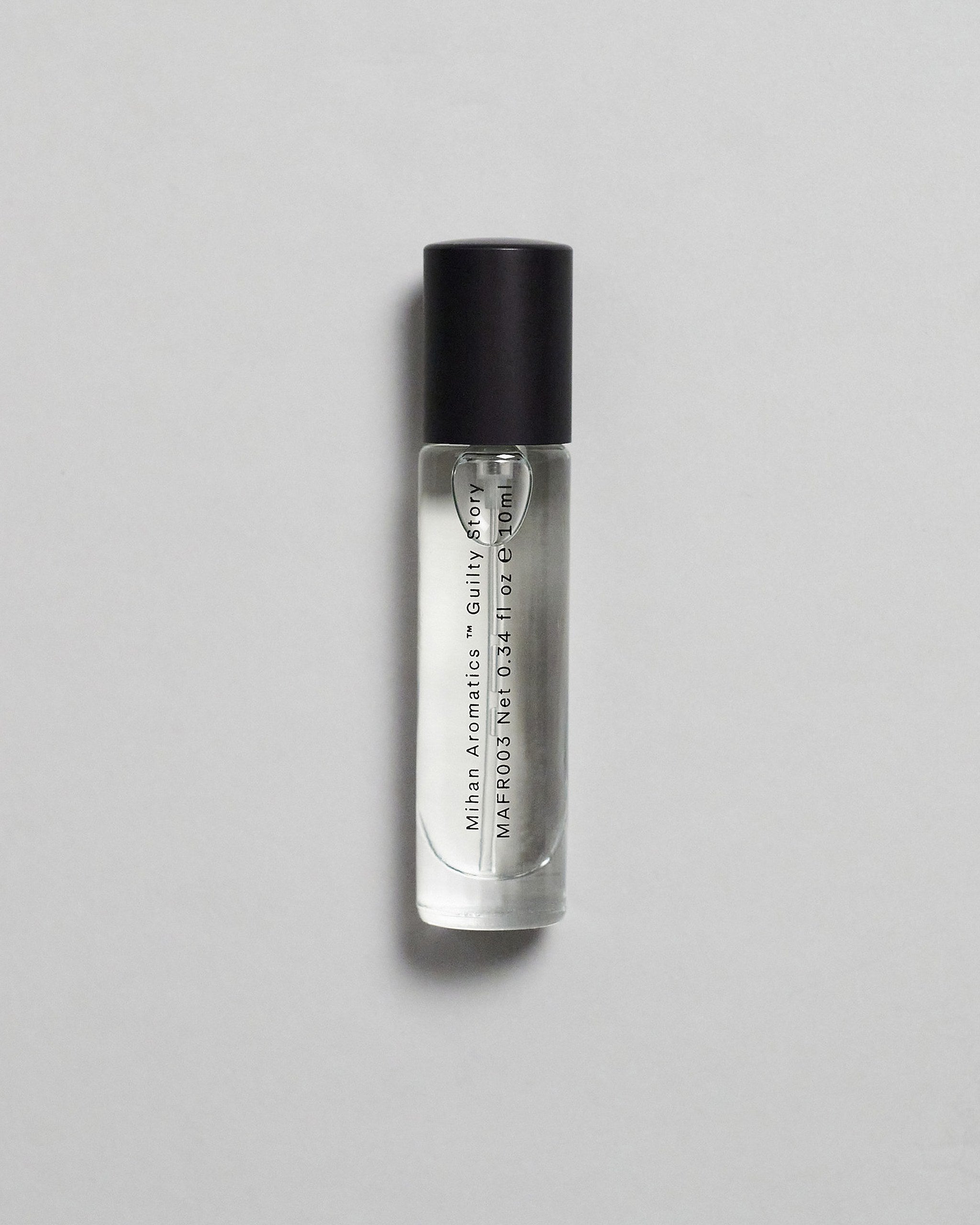 Mihan Aromatics Guilty Story parfum 10ml bottle with black cap on a pale grey backdrop