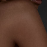 Close view of a bare shoulder and lips in soft shadow, Mihan Aromatics Guilty Story parfum campaign
