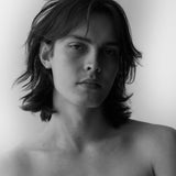 Black and white portrait of a model with tousled shoulder length hair, Mihan Aromatics Kirra Curl parfum campaign