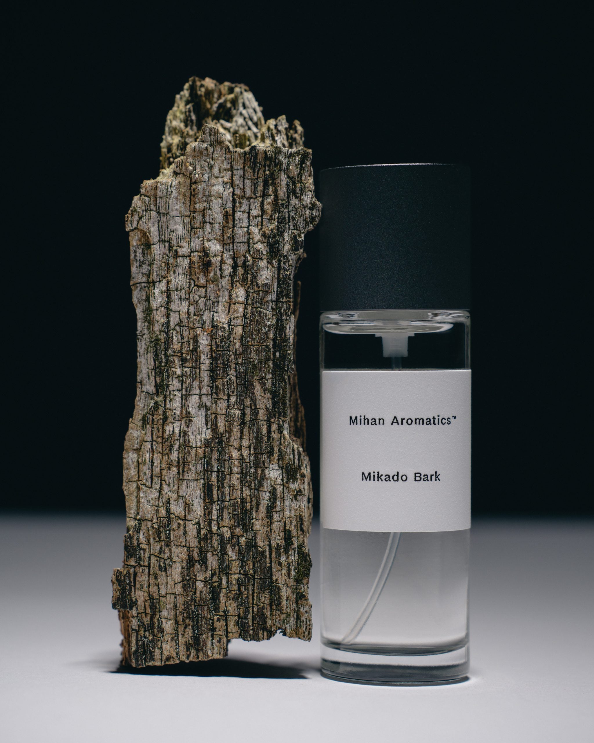Mihan Aromatics Mikado Bark parfum 100ml bottle standing against tree bark