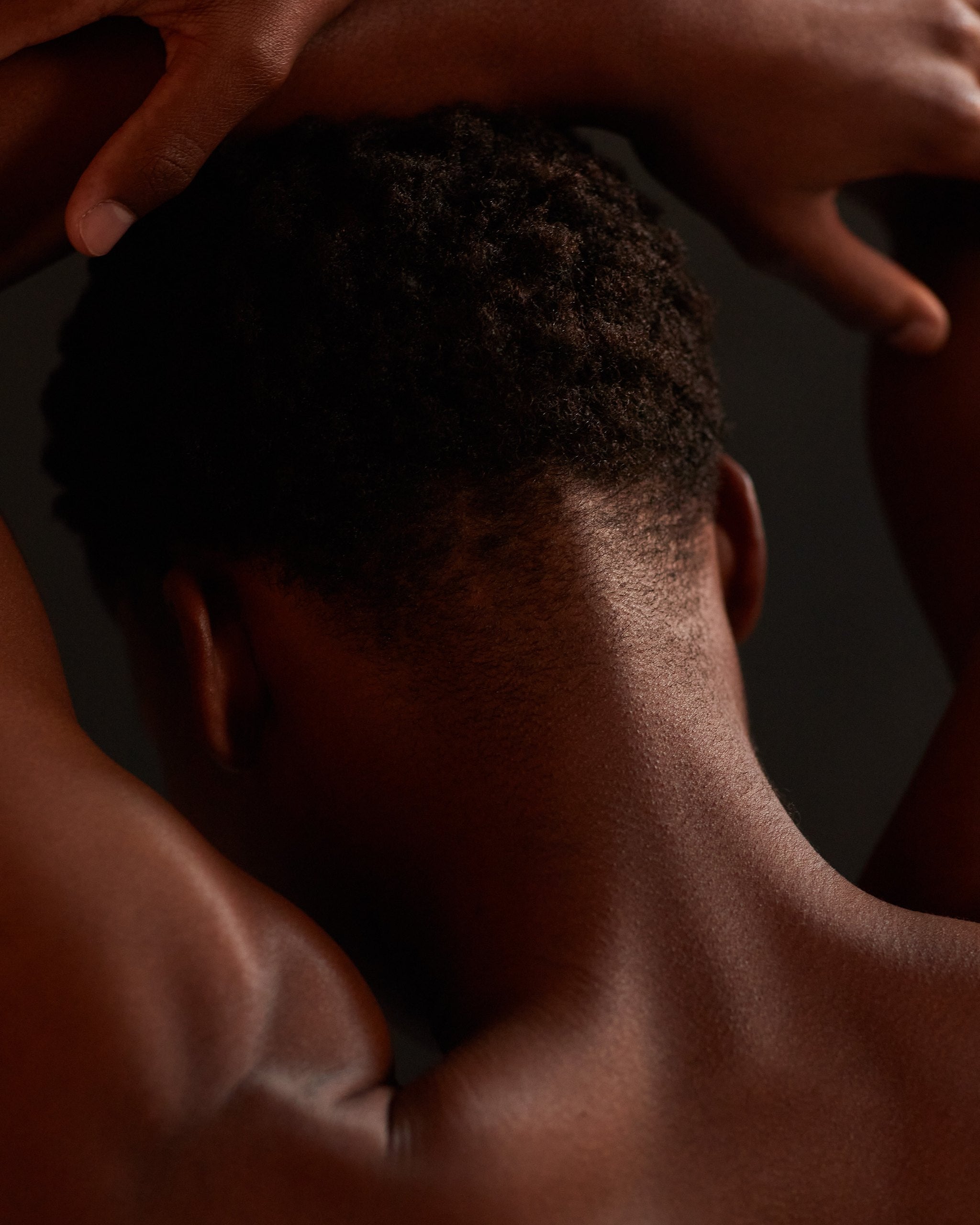 Model with hands resting behind the head in warm low light, Mihan Aromatics Mikado Bark parfum campaign