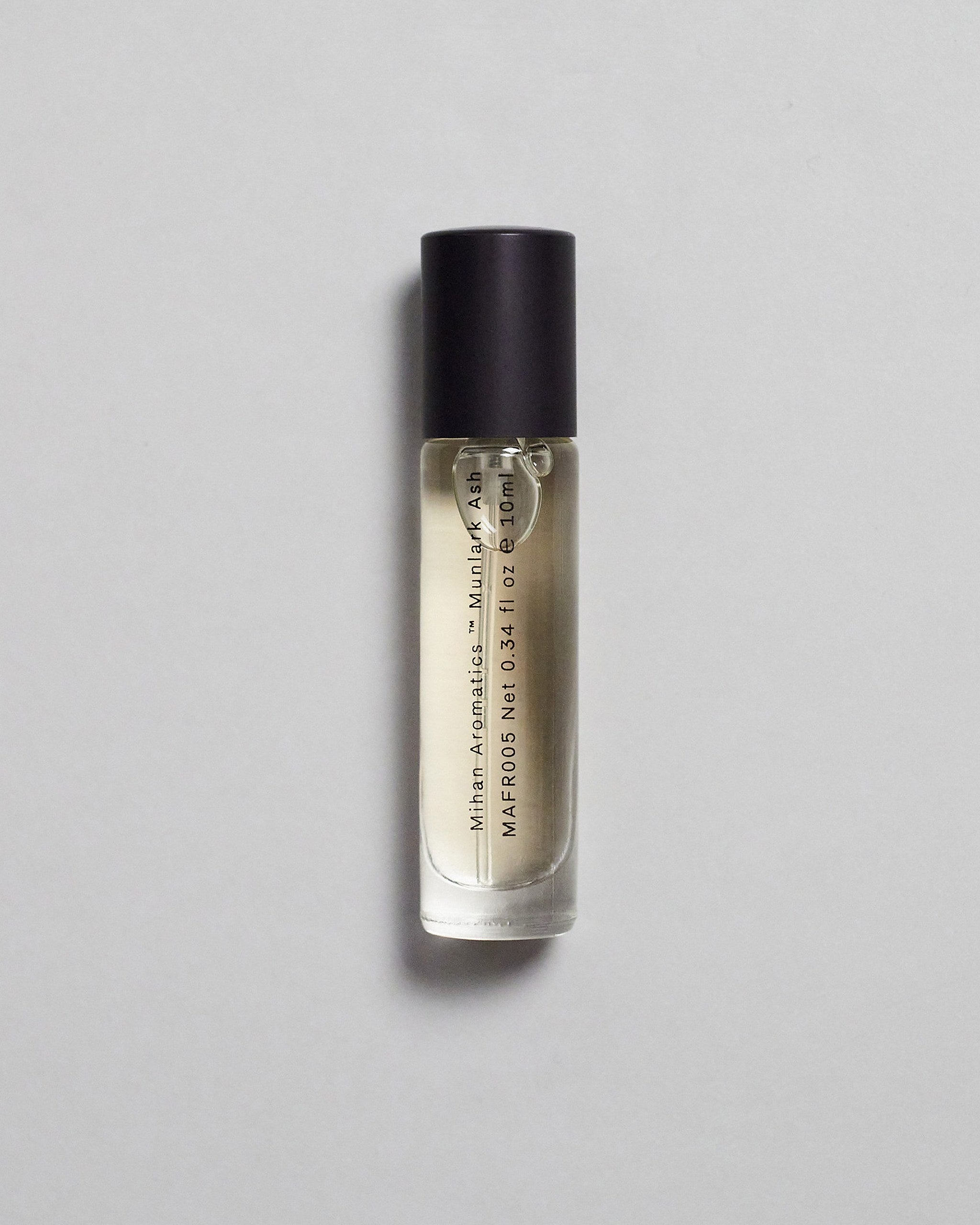 Mihan Aromatics Munlark Ash parfum 10ml bottle with black cap on a pale grey backdrop