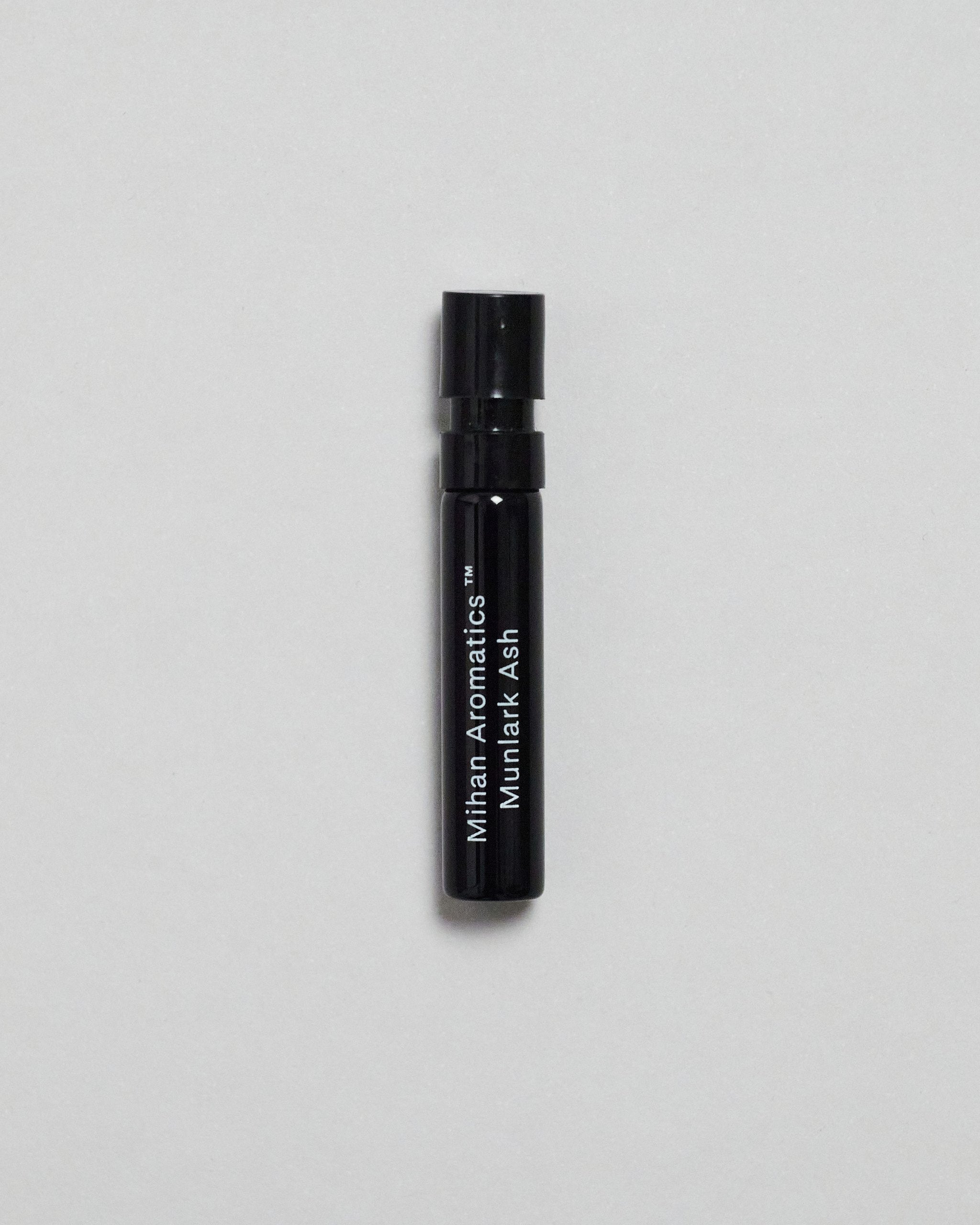 Mihan Aromatics Munlark Ash parfum 2ml sample vial on a pale grey backdrop