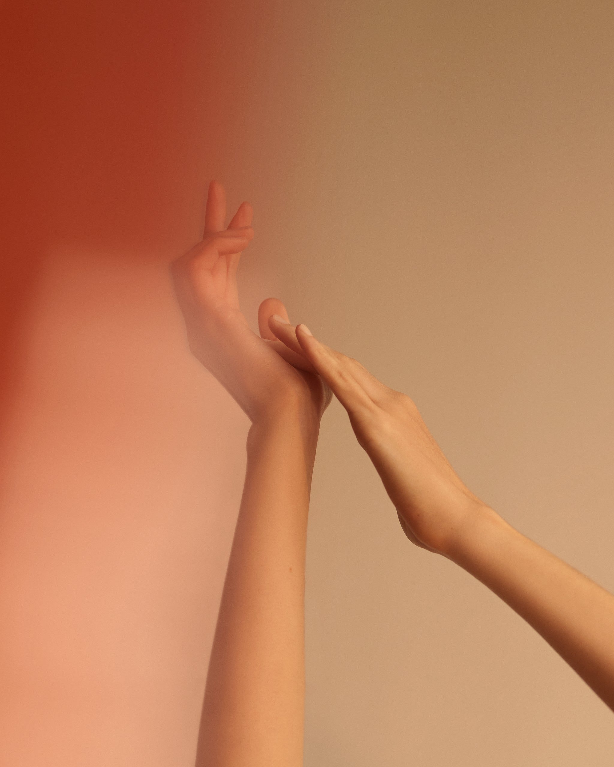 Two hands reaching upward against a warm amber wall, Mihan Aromatics Munlark Ash parfum campaign