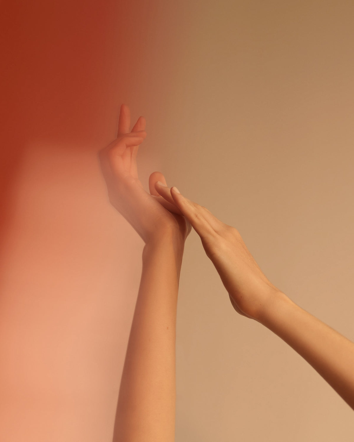Two hands reaching upward against a warm amber wall, Mihan Aromatics Munlark Ash parfum campaign