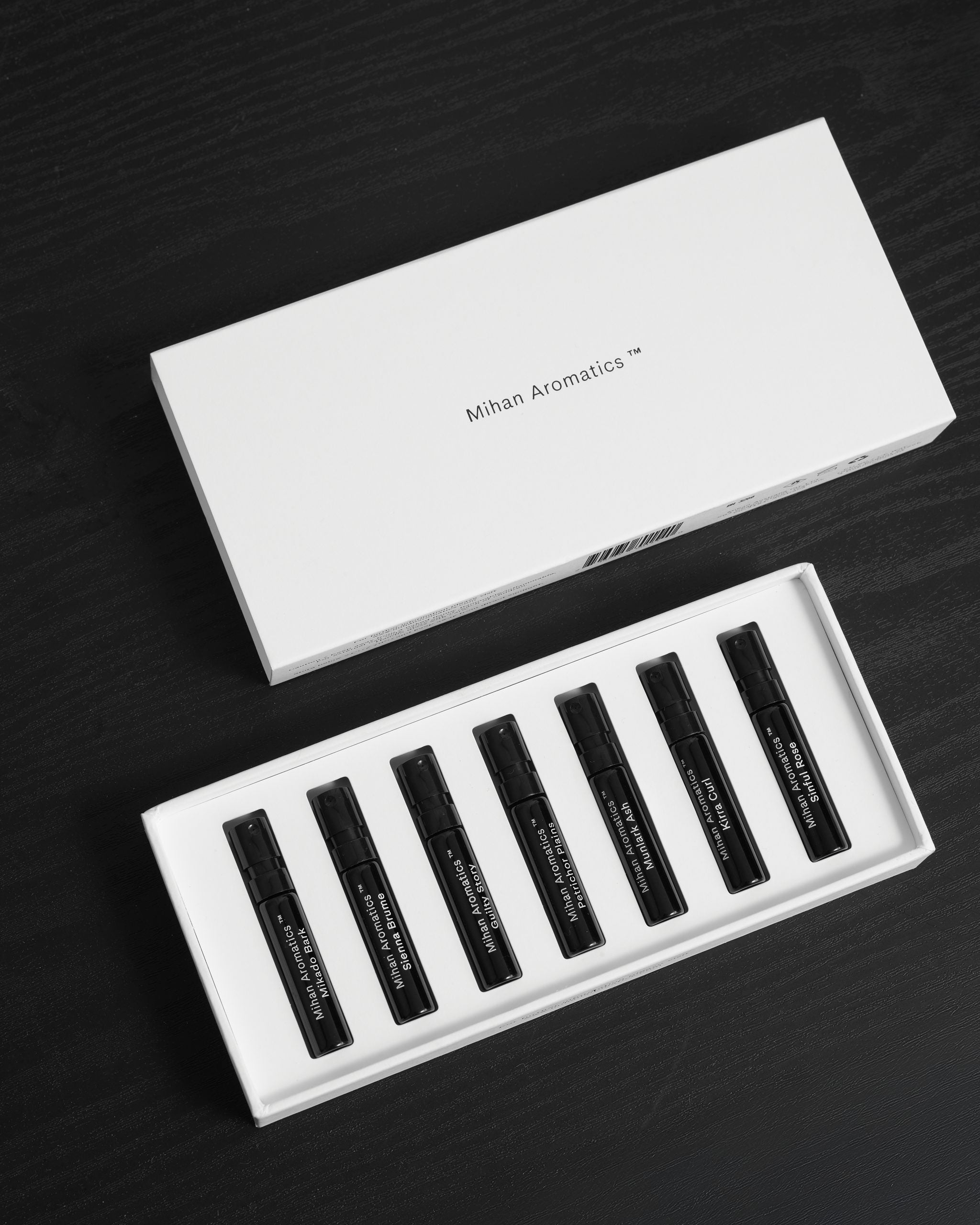 Mihan Aromatics Discovery Set open on dark timber, seven parfum vials beside the lid