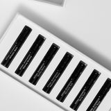 Close view of the seven labelled 2ml parfum vials inside the Mihan Aromatics Discovery Set