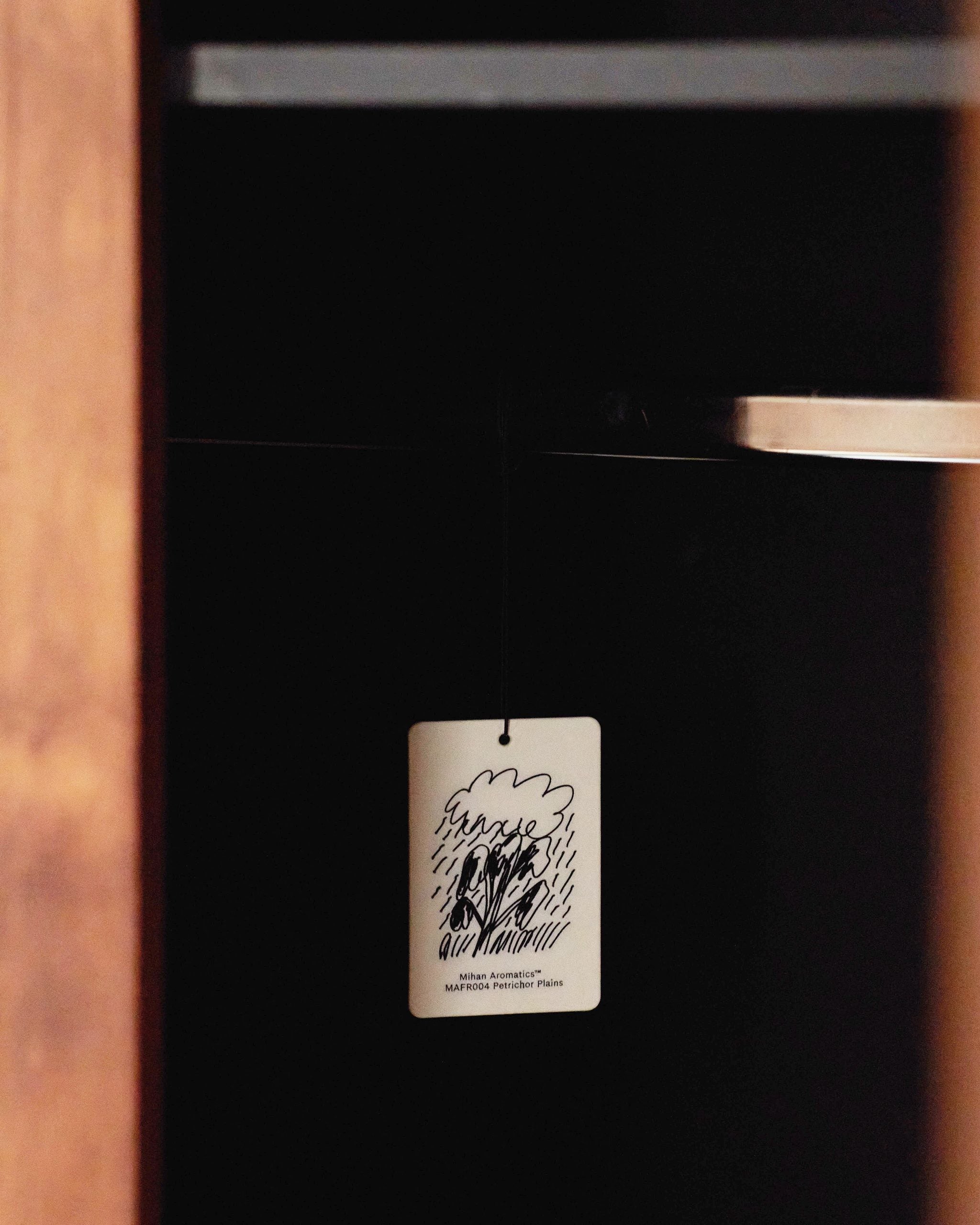 Mihan Aromatics Petrichor Plains Air Fragrance hanging inside a dark timber wardrobe