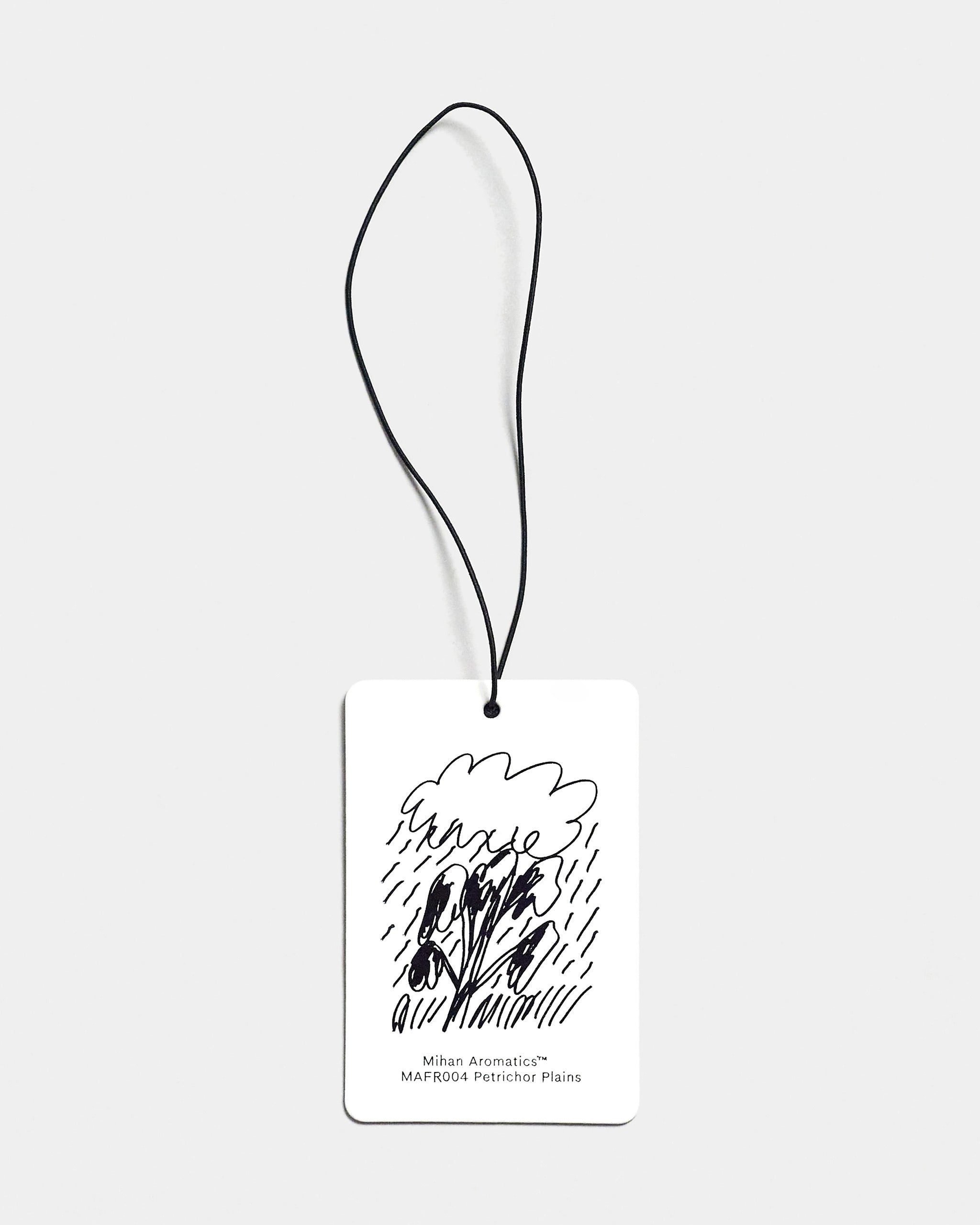 Mihan Aromatics Petrichor Plains Air Fragrance card with illustrated design and black cord on a Studio Grey backdrop
