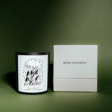 Mihan Aromatics Petrichor Plains candle beside its white gift box on a deep green backdrop