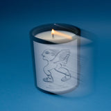 Lit Mihan Aromatics Sienna Brume candle with soft motion blur on a blue backdrop