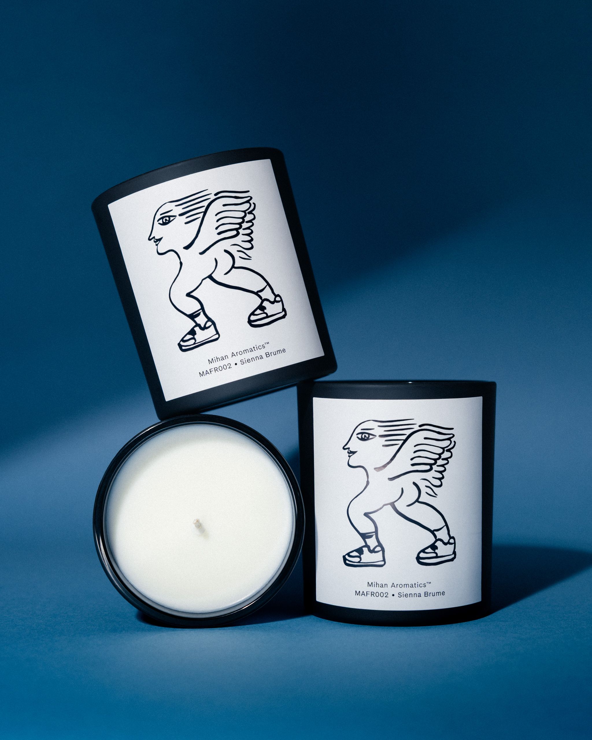 Three Mihan Aromatics Sienna Brume candles stacked together, one showing its white wax