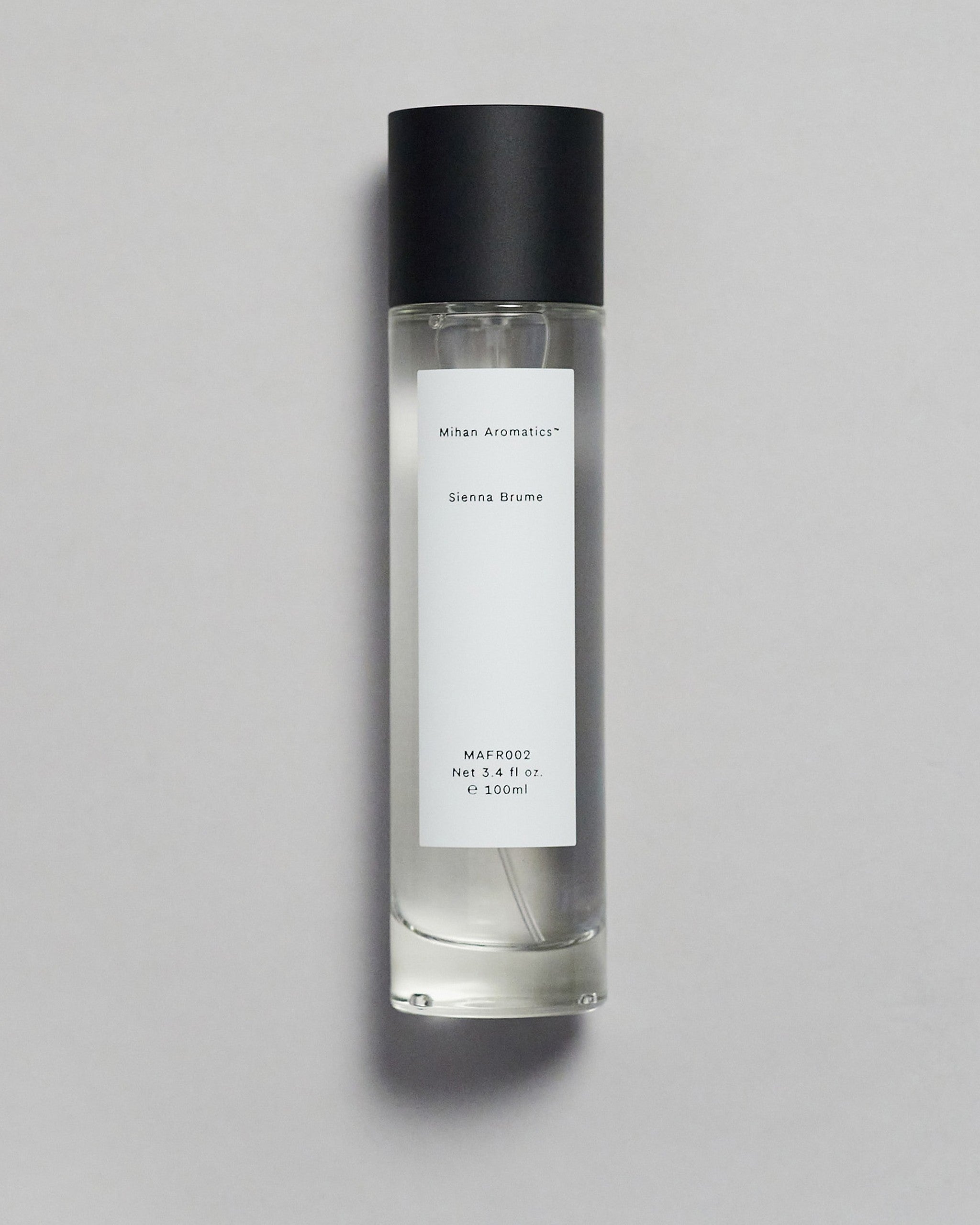 Mihan Aromatics Sienna Brume parfum 100ml bottle with black cap on a pale grey backdrop