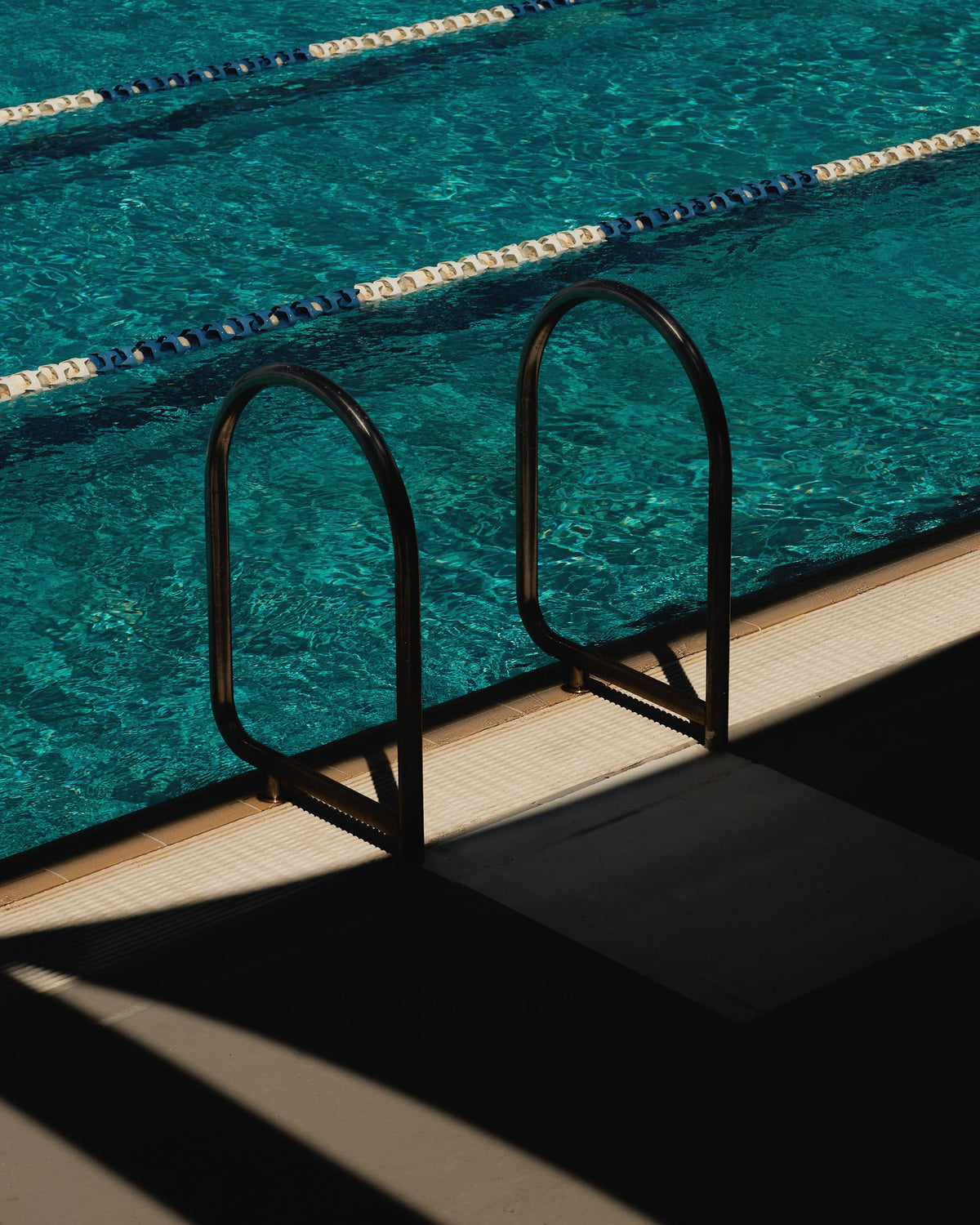 Pool ladder and lane ropes over turquoise water, the summer pool memory behind Mihan Aromatics Sienna Brume parfum