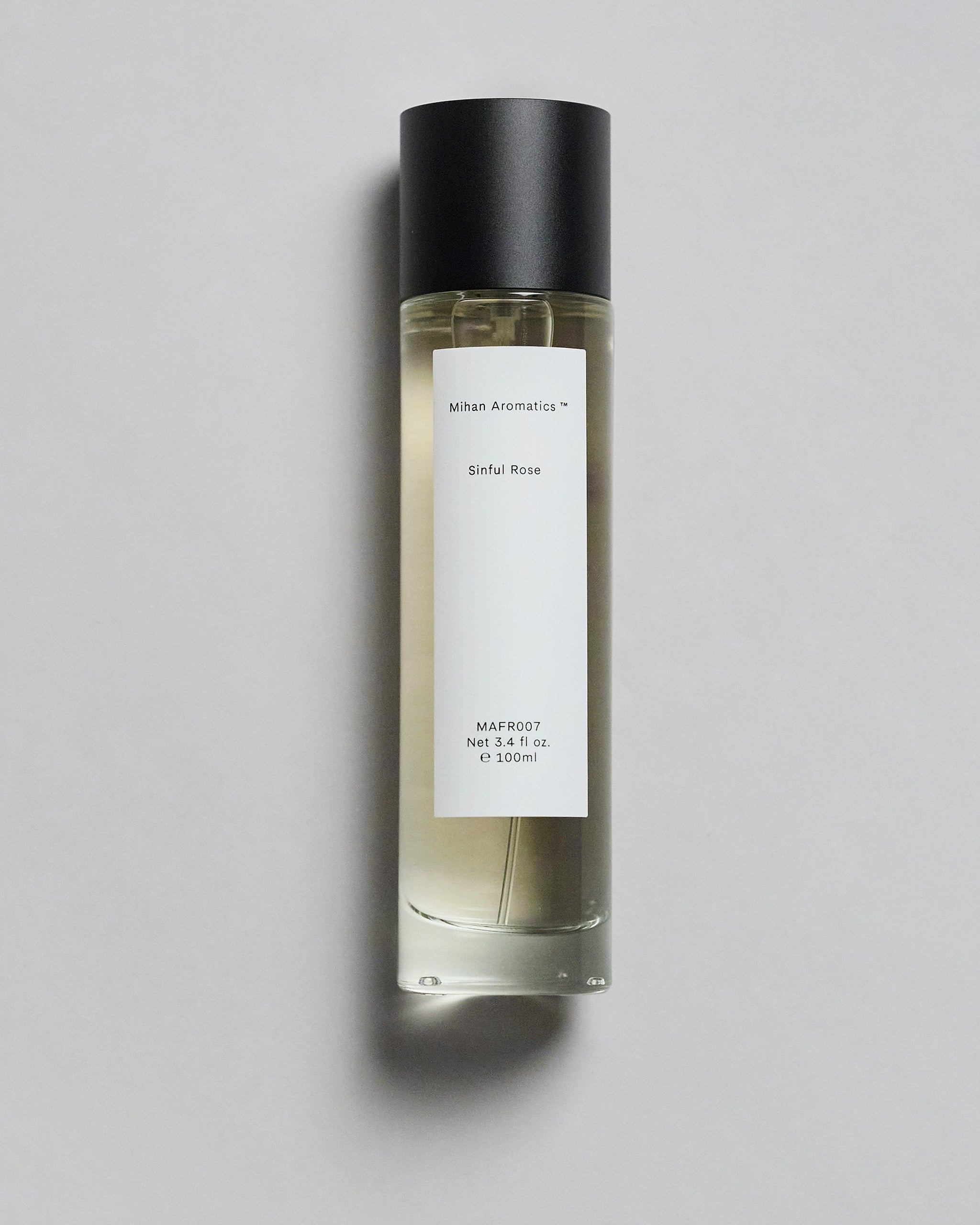 Mihan Aromatics Sinful Rose parfum 100ml bottle with black cap on a pale grey backdrop