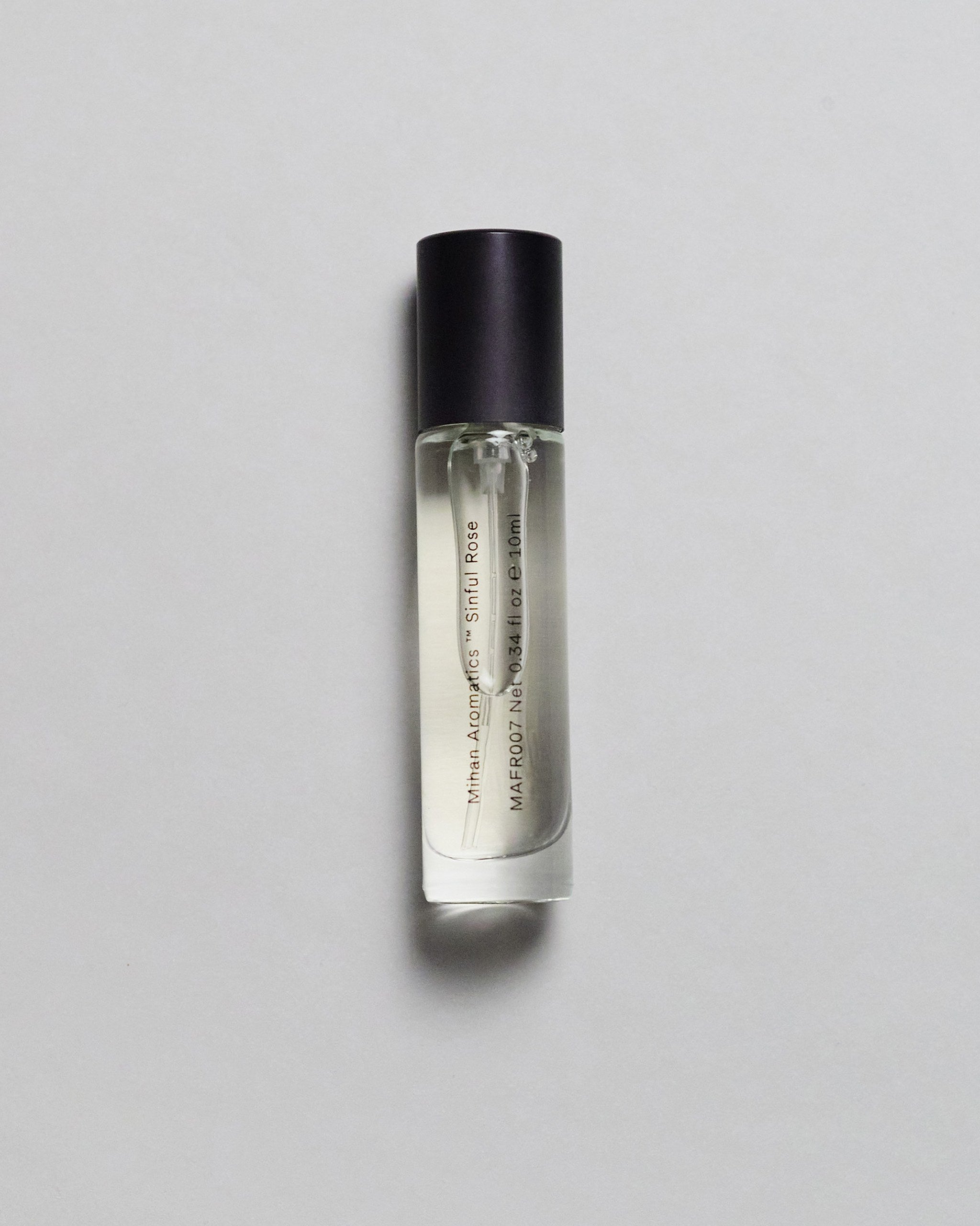 Mihan Aromatics Sinful Rose parfum 10ml bottle with black cap on a pale grey backdrop