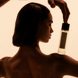 Model in profile balancing a Mihan Aromatics Sinful Rose parfum bottle on her shoulder