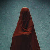 Figure veiled in deep red cloth against a teal backdrop, Mihan Aromatics Sinful Rose parfum campaign
