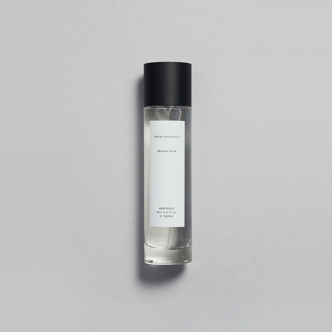 Mikado Bark Parfum bottle on a gray background, evoking autumn's calm with crisp air and soft sunlight.