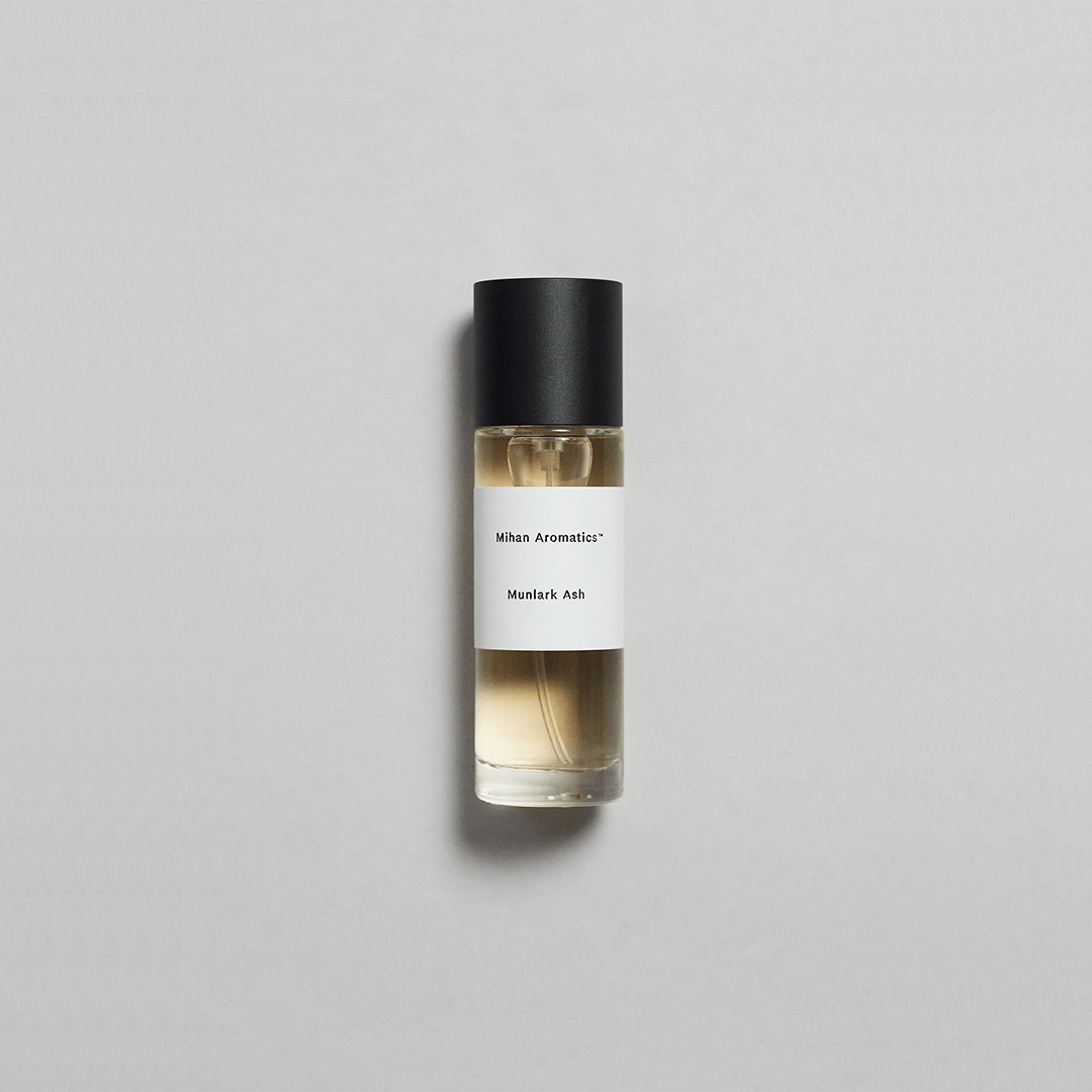 Munlark Ash Parfum by Mihan Aromatics in a sleek glass bottle on a soft gray background.