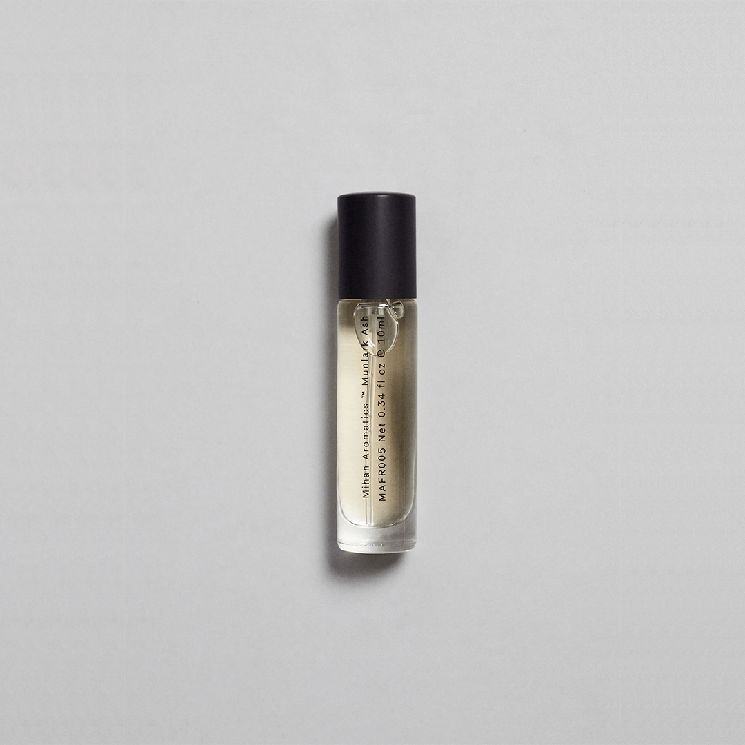 Munlark Ash Parfum by Mihan Aromatics in a sleek glass roller bottle, evoking nature's calm essence.