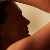 Profile silhouette of a woman with hair pulled back, showcasing a serene expression and soft lighting.