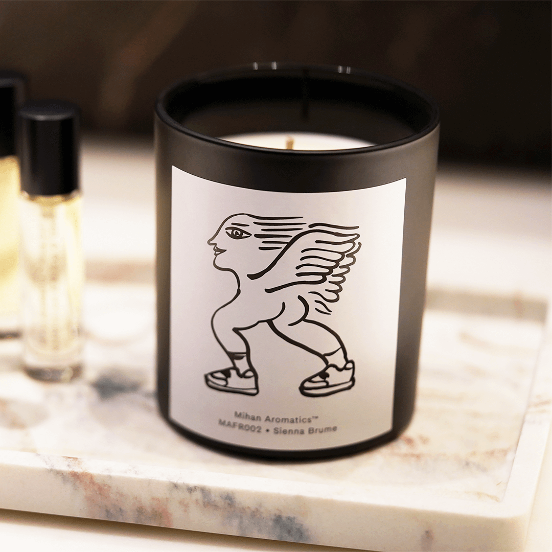 Sienna Brume Candle in black vessel with whimsical design, showcasing luxury hand-poured soy wax for a long-lasting burn.