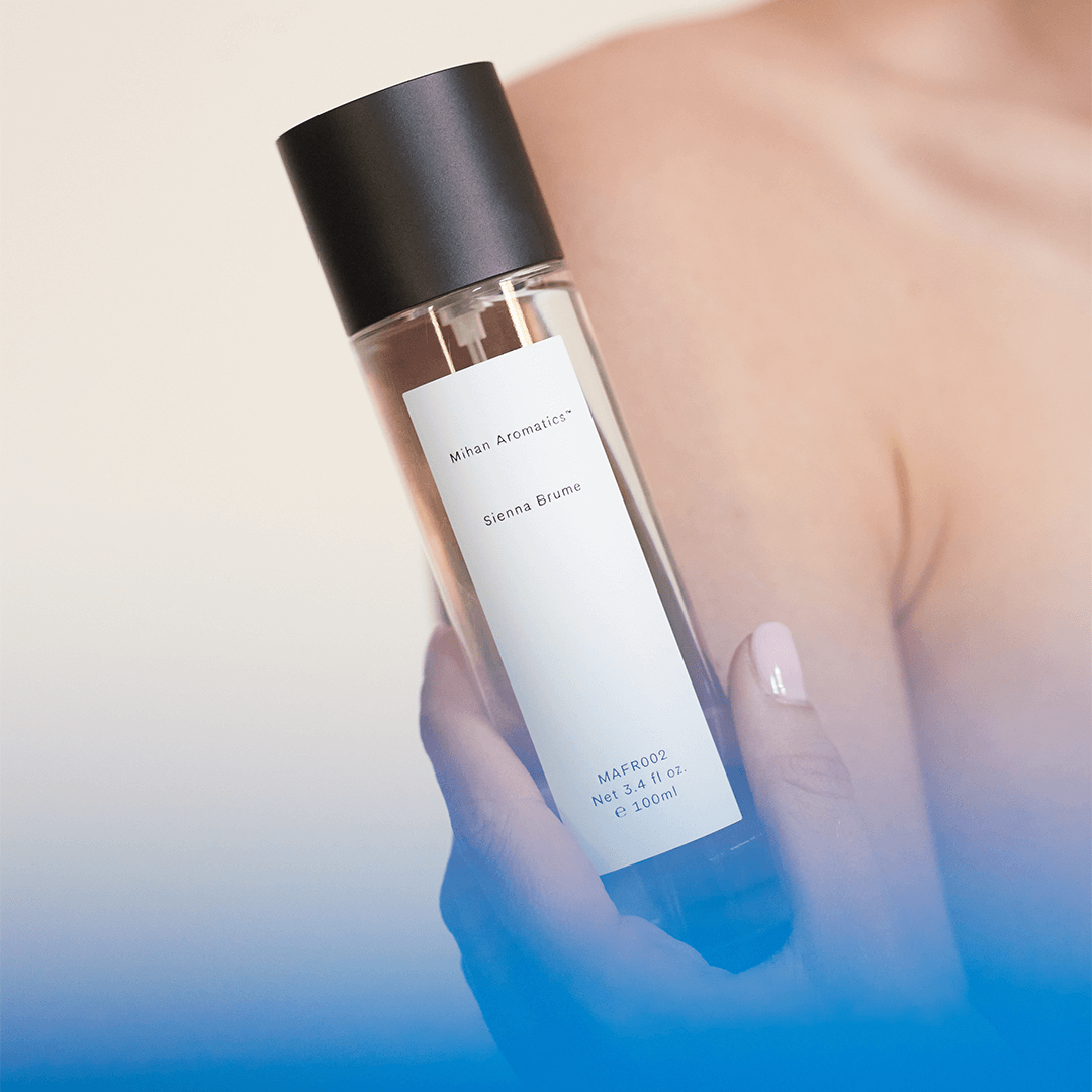 Sienna Brume Parfum bottle held by a person, showcasing its elegant design and refreshing summer fragrance.