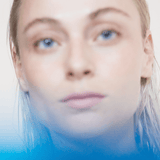 Close-up of a woman with wet hair and a soft expression, evoking a sense of calm and leisure.